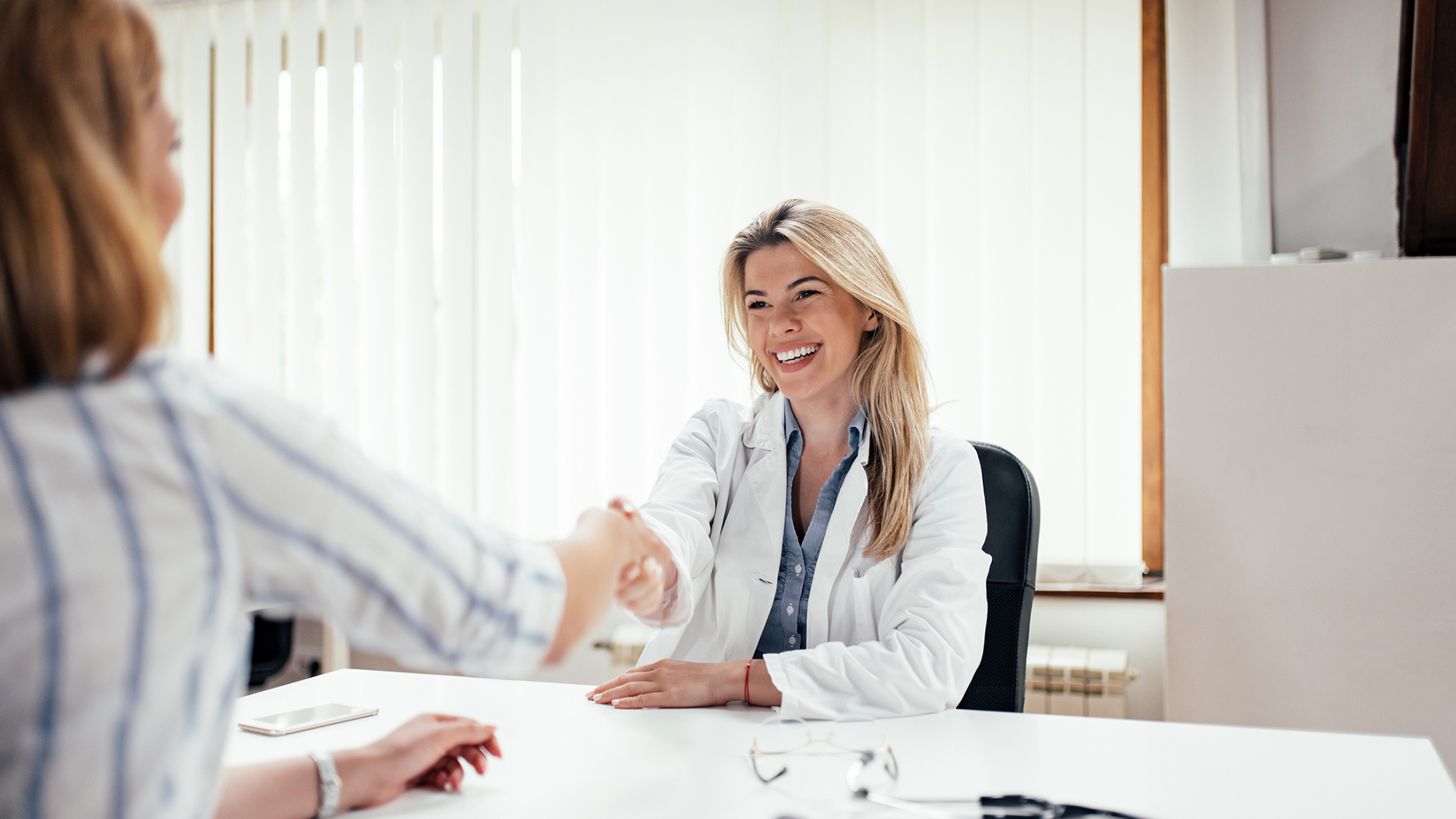 Physician shaking hands with a patient
